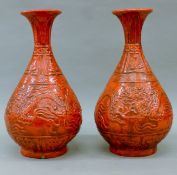 A pair of Chinese red ground porcelain vases decorated with dragons.