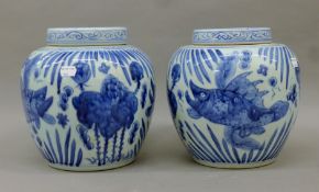 A pair of Chinese blue and white porcelain ginger jars decorated with fish. 23 cm high.