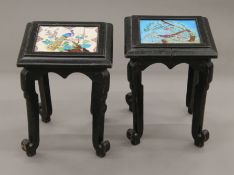 A pair of ebonised tiled-topped urn stands. Each 31.5 cm squared x 41 cm high.