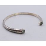 A silver torque bangle set with blue stones. 0.5 cm high.