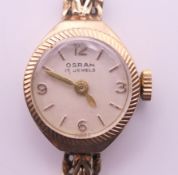 A 9 ct gold ladies' Osram wristwatch. 1.5 cm diameter. 12.1 grammes total weight.
