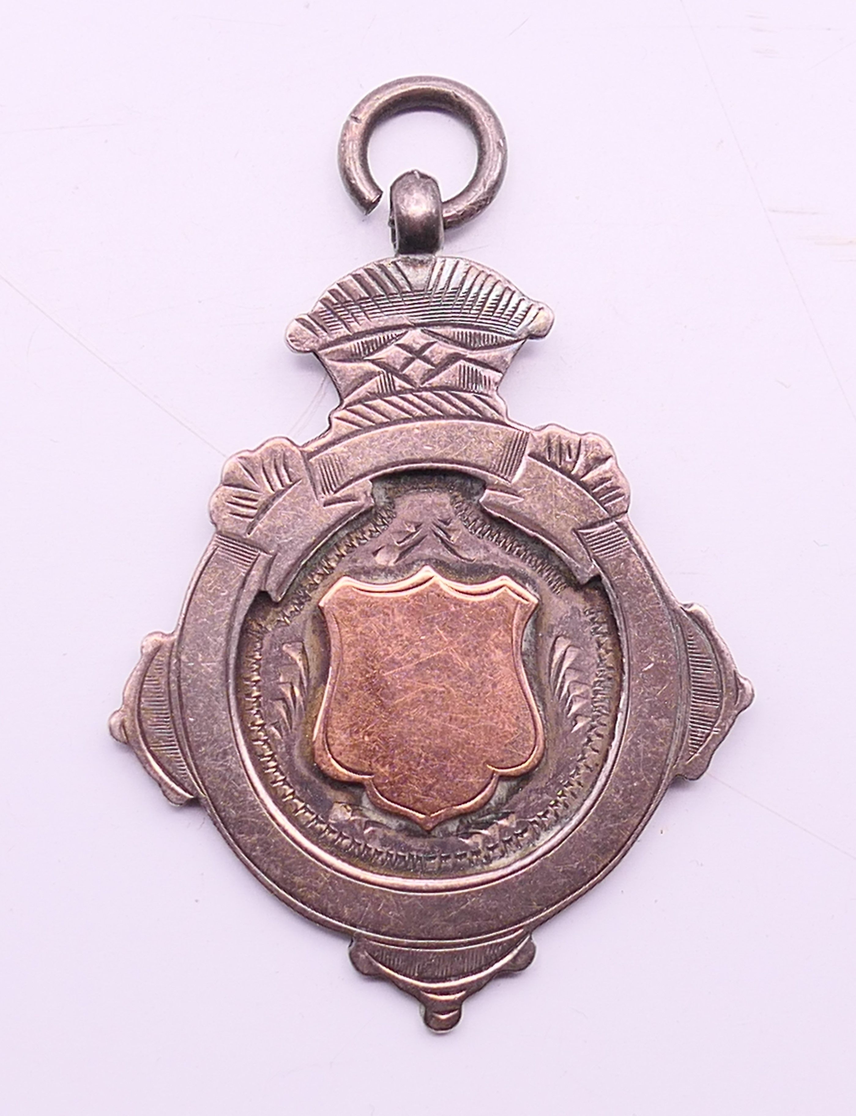 A silver fob with rose gold inlay. 4.5 cm high.