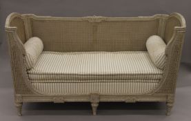 A 19th century painted caned day bed. 170 cm long.