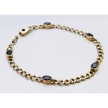 A 9 ct gold five stone sapphire set curb link bracelet. 8.7 grammes. 18.5 cm long. 8.