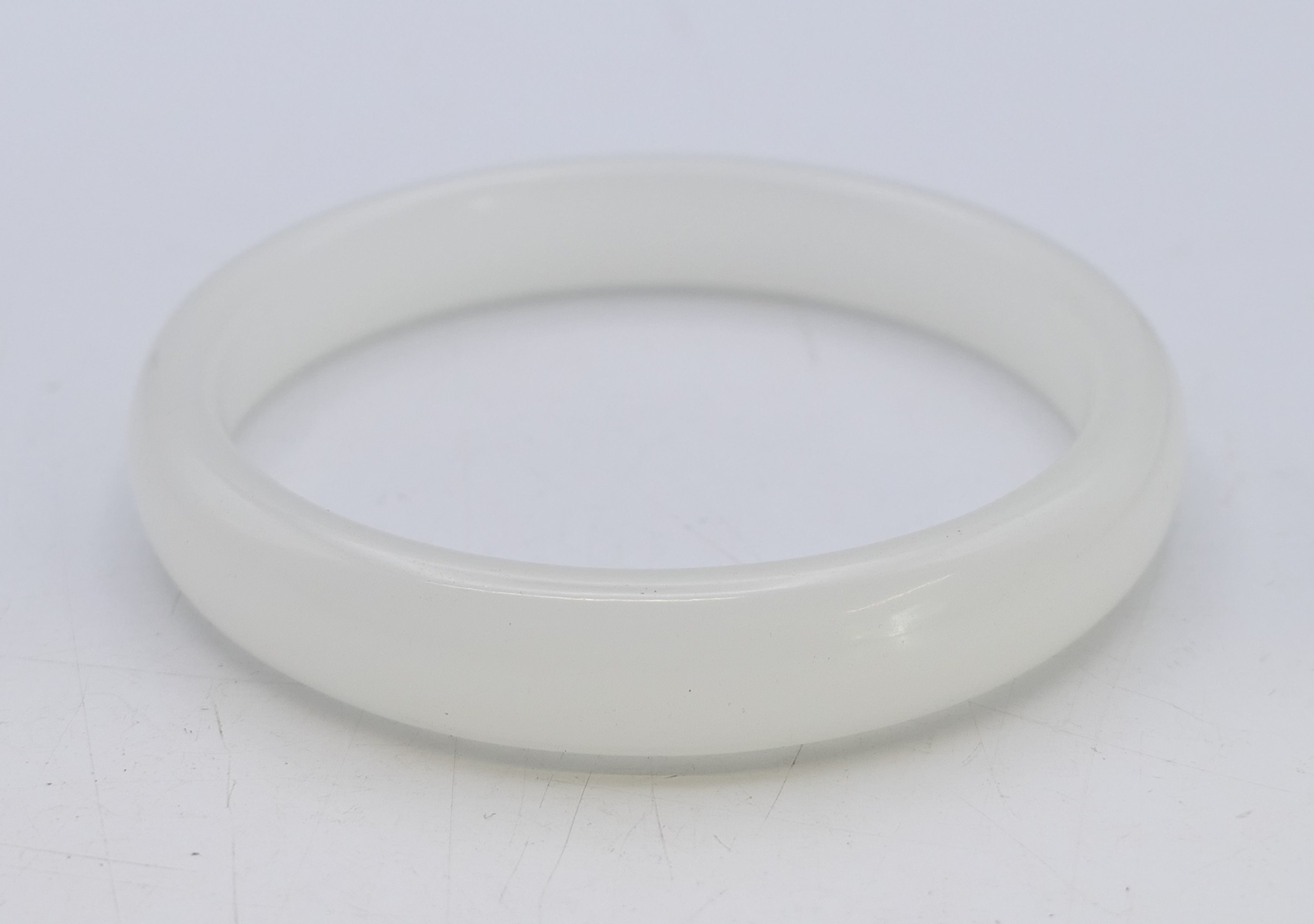 A white jade bangle. 1.25 cm high, 0.75 cm deep, 6.25 cm internal diameter.
