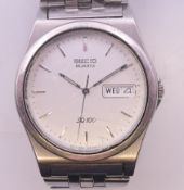 A Seiko quartz SQ100 day date gentleman's stainless steel wristwatch. 3.5 cm diameter.