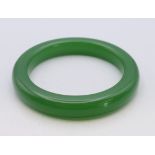 A green jade bangle. 1 cm wide, 6 cm internal diameter.
