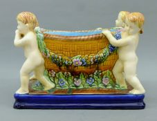 A Majolica planter decorated with a cherub. 31 cm long.