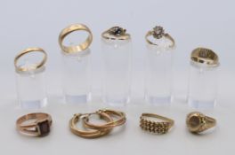 Eight 9 ct gold rings and a pair of 9 ct gold hoop earrings. The wedding band ring size U. 27.