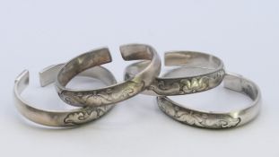 Four Chinese white metal bangles with fish and lotus pattern. 1.25 cm high, 6.