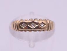 A 9 ct gold three stone diamond ring. Ring size L. 1.3 grammes total weight.