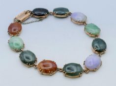 A 9 K gold and multi-coloured jade bracelet. 20 cm long.