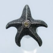 An unmarked silver and diamond star fish ring. Star fish 4 cm high. Ring size N/O.