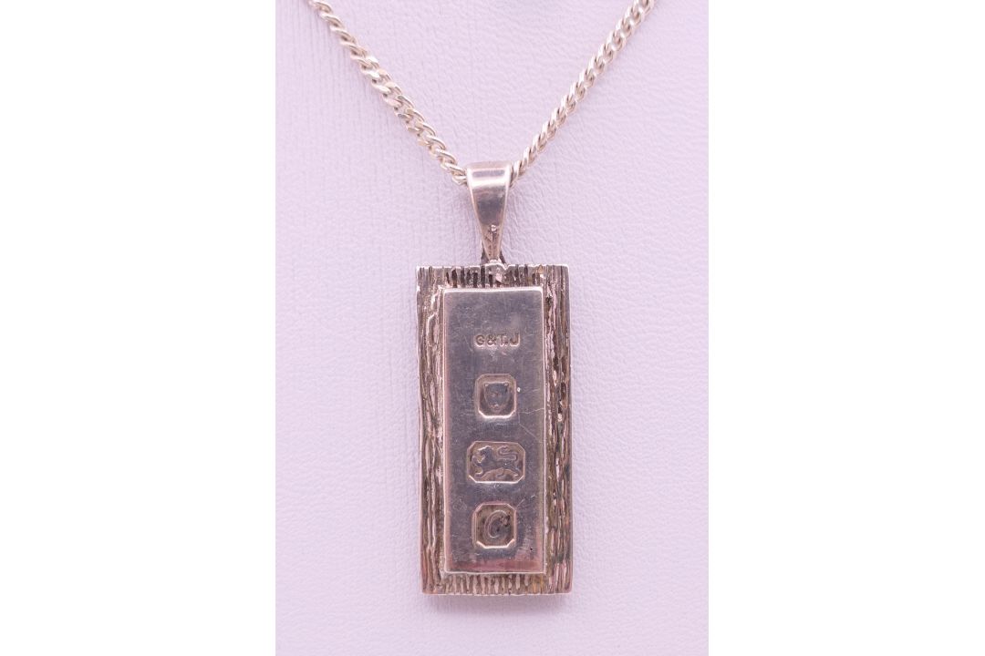 A silver ingot pendant on a silver chain. - Image 1 of 6
