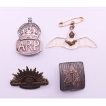 Four WWII military and other badges. The largest 5 cm wide.