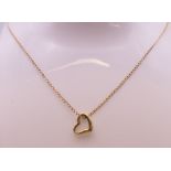 A 9 ct gold heart shaped pendant on a 9 ct gold fine chain. Pendant 1 cm x 1 cm, chain 42 cm long.