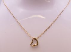 A 9 ct gold heart shaped pendant on a 9 ct gold fine chain. Pendant 1 cm x 1 cm, chain 42 cm long.
