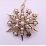 A 9 ct gold and seed pearl starburst brooch. 2.5 cm diameter. 4.1 grammes total weight.