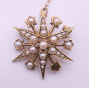 A 9 ct gold and seed pearl starburst brooch. 2.5 cm diameter. 4.1 grammes total weight.