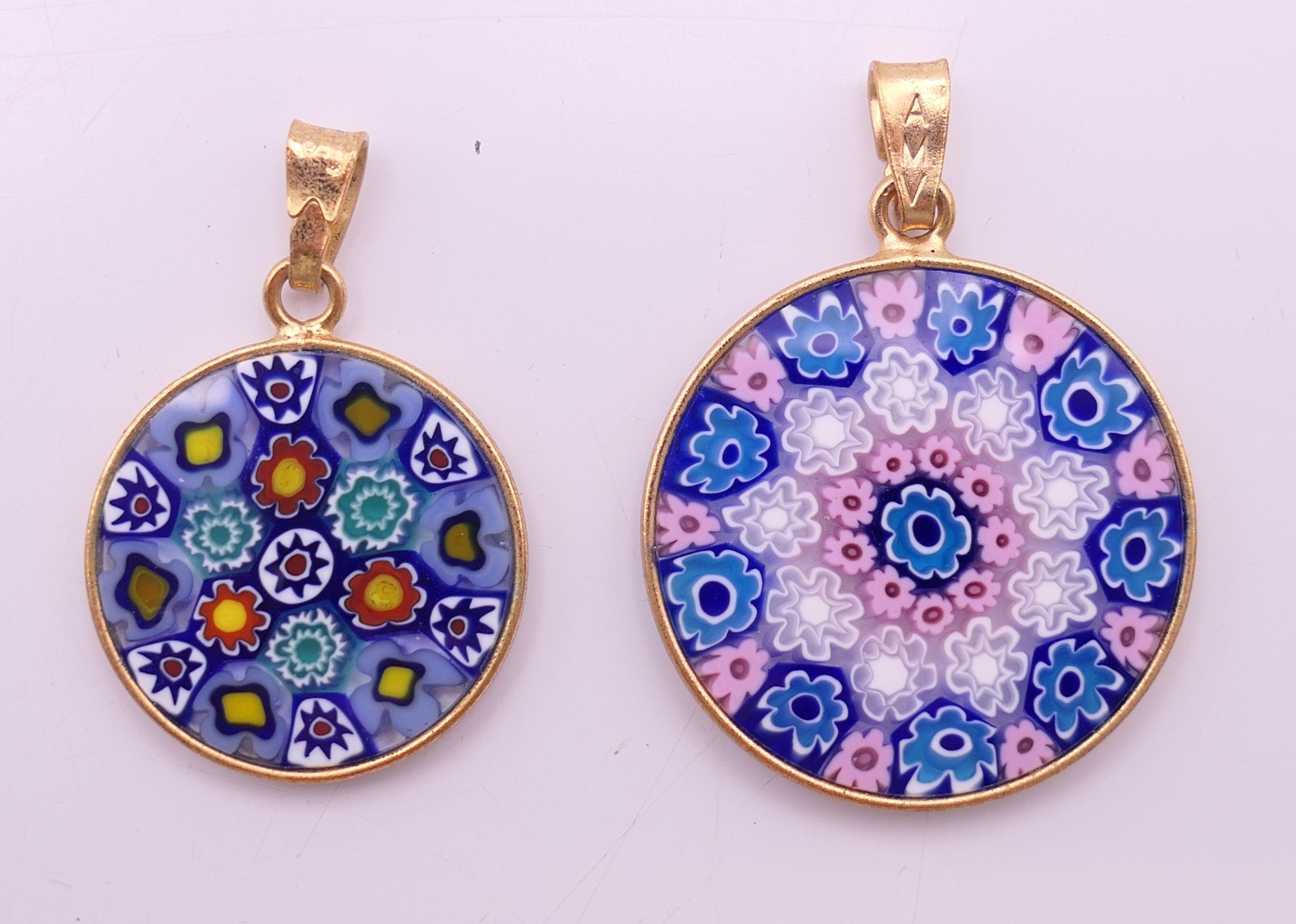 Two silver gilt Venetian millefiori glass pendants. 2.5 and 2 cm diameter respectively.