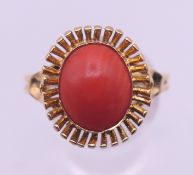 An 18 ct gold coral ring. Ring size V. 5.3 grammes total weight.