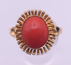 An 18 ct gold coral ring. Ring size V. 5.3 grammes total weight.