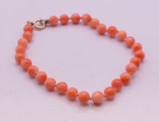 A salmon coral bead bracelet. 18 cm long.