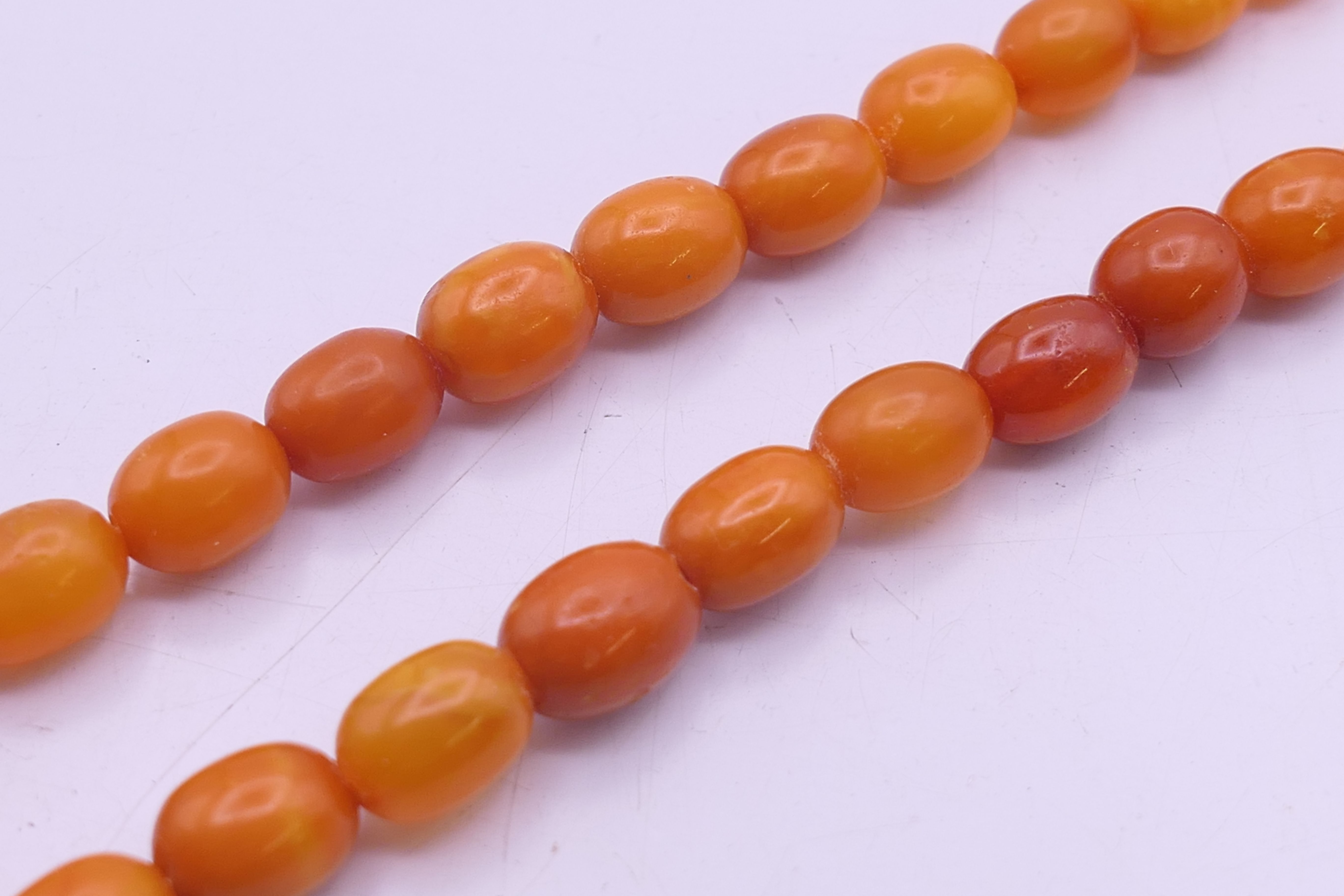 A string of butterscotch amber graduated beads. 64 cm long. 23.3 grammes total weight. - Image 4 of 10