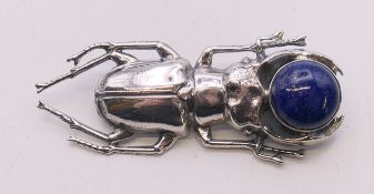 A silver and lapis lazuli beetle brooch. 5.5 cm long.