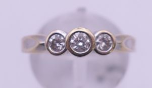 An unmarked white gold three stone diamond ring. Ring size P. 3.7 grammes total weight.