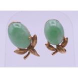 A pair of 18 ct gold and jade earrings (one lacking back). 1.5 cm high.
