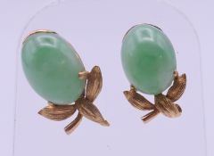 A pair of 18 ct gold and jade earrings (one lacking back). 1.5 cm high.