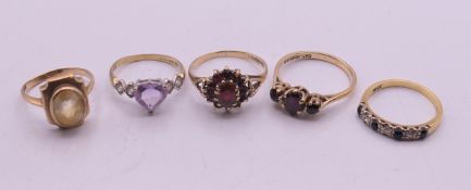 Four 9 ct gold rings (9.6 grammes total weight) and an 18 ct gold ring (2.8 grammes total weight).