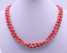 A string of red coral beads with a 9 ct gold clasp. 83 cm long.