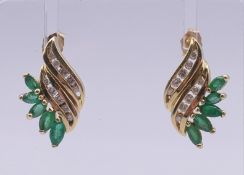 A pair of 14 ct gold, diamond and emerald earrings. 2 cm high. 5.4 grammes total weight.