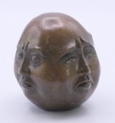 A brass four face Buddha head. 5.5 cm high.
