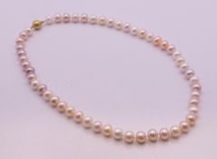 A pearl necklace on a 9 ct gold clasp. 47 cm long.
