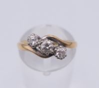 An 18 ct gold and platinum three stone diamond ring. 3.6 grammes total weight. Ring size K/L.