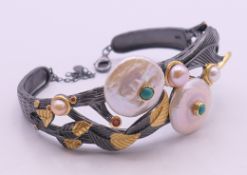 A silver, gold and pearl bangle. 6 cm inner diameter.