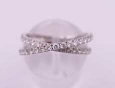 A Luke Stockley 18 ct white gold and diamond crossover ring. 2.6 grammes total weight. Ring size N.