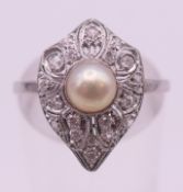 An Art Deco platinum, diamond and pearl ring. Ring size M/N.