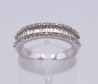 An 18 ct white baguette gold diamond half hoop ring. 5 grammes total weight. Ring size L.