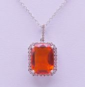 A fire opal pendant on an 18 ct white gold chain. The pendant 2 cm high.