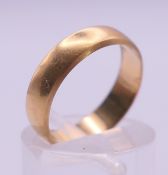 An 18 ct gold wedding band. Ring size L/M. 3.