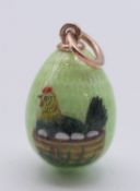 A 14ct gold-mounted enamel chicken and egg pendant. 2.