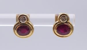 A pair of 18 K ruby and diamond ear studs. Each 9 mm high. 4.6 grammes total weight.