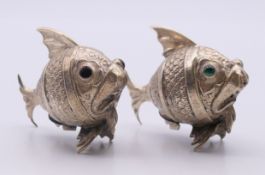 A pair of unmarked silver fish-form peppers. Each 4.5 cm high.