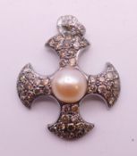 An 18 ct white gold, diamond and pearl cross form pendant. 3 cm high. 3.9 grammes total weight.