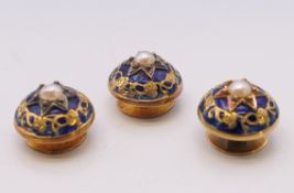 A boxed set of three blue enamel and seed pearl shirt studs. Each 1.25 cm diameter.