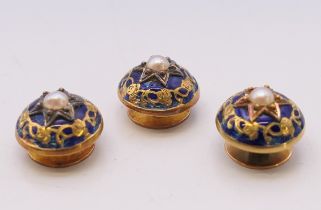 A boxed set of three blue enamel and seed pearl shirt studs. Each 1.25 cm diameter.